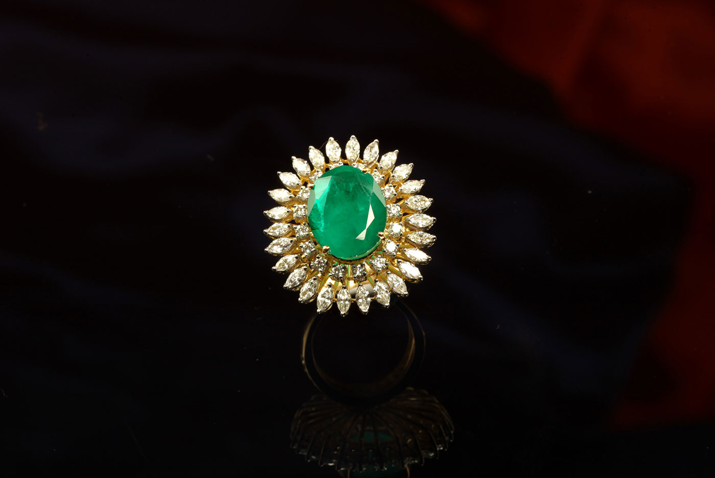 Original emerald in the mid of the round and marquise shaped diamond studded ring is what
makes it a seductive cocktail ring.